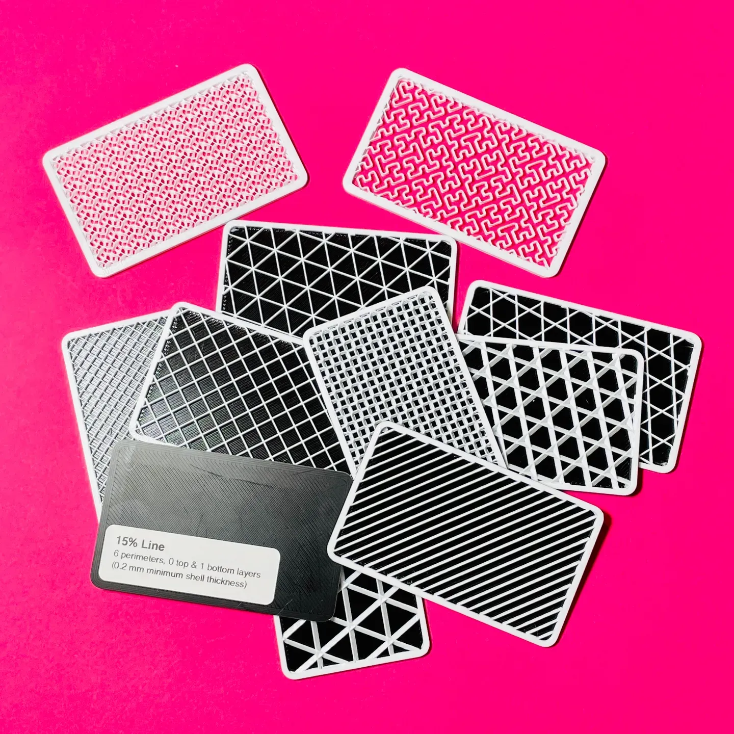 Gridfinity Infill swatches. Model by me. A group of 3D printed infill swatches against a pink background.