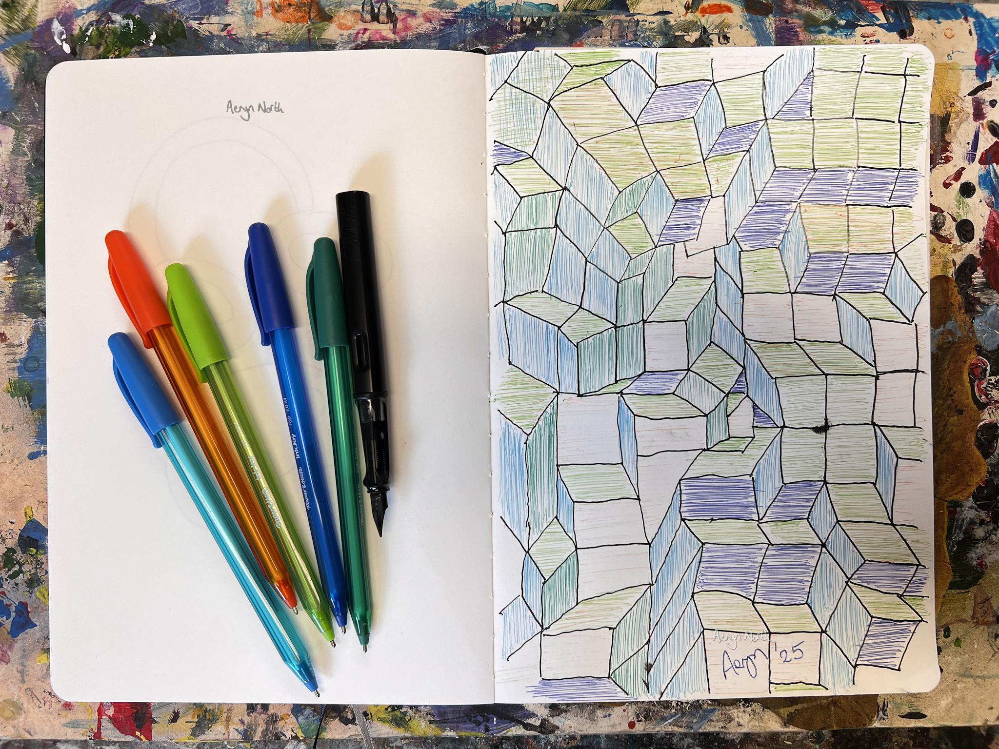 An open notebook is positioned on a colorful, vibrant background. The artwork in the notebook is a geometric pattern consisting of black lines and shapes. On the left side of the notebook, there are several pens.