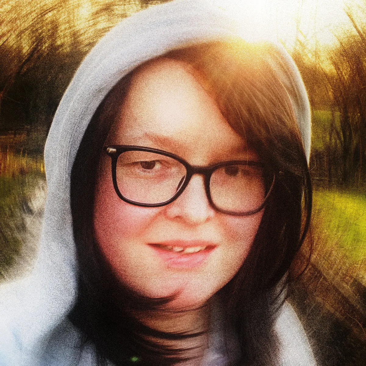 A stylised selfie in vibrant colours with swirling background of Aeryn wearing a grey hoodie and black-rimmed glasses