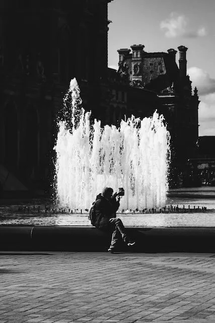 A man sihlouetted against a thick fountain