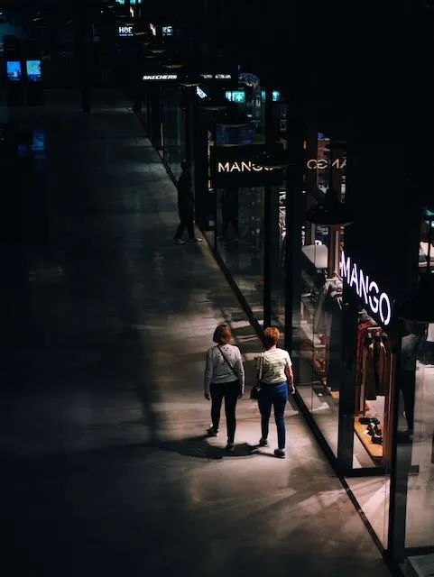 Two people walking through a shopping centre
