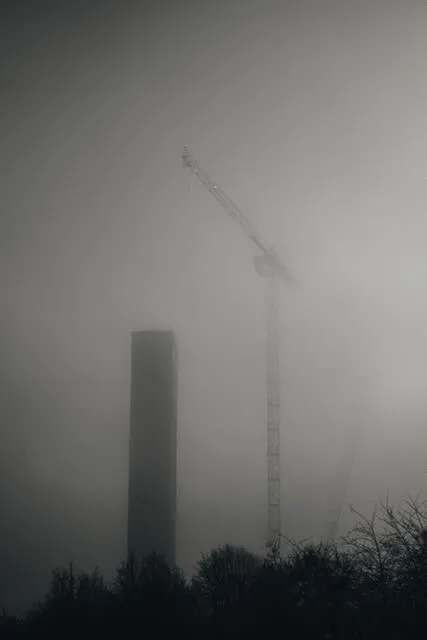 A building a crane obscured by fog