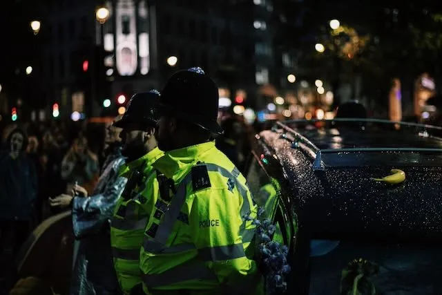 Two police man stand guard in front of a herse in Trafalgar Square