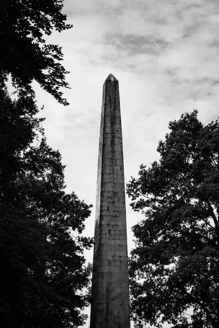 An obelisk rises from among the trees