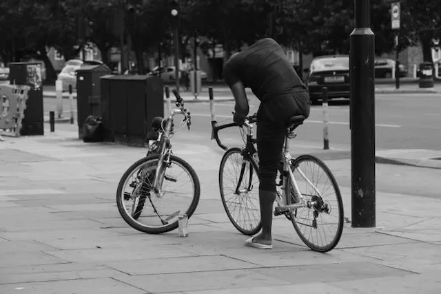 A man leans over his bicycle