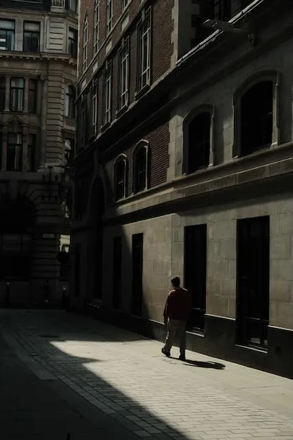 A person walks down a harshly lit street