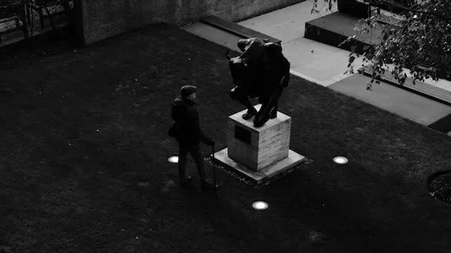 A man considers a statue of a crouching minotaur