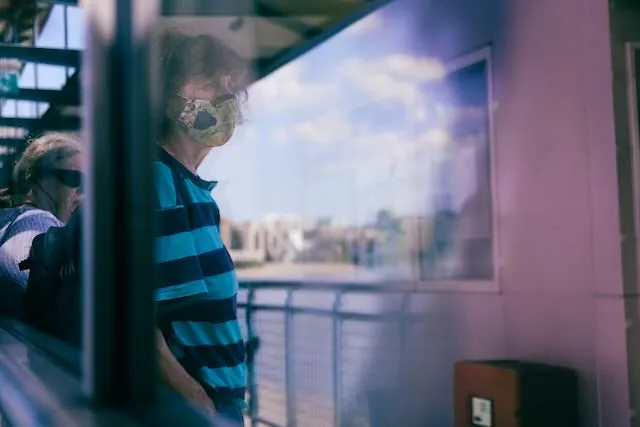 A woman wears a mask on a hot day in the east end.