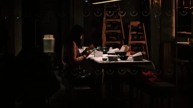 A woman reads alone in an empty restaurant
