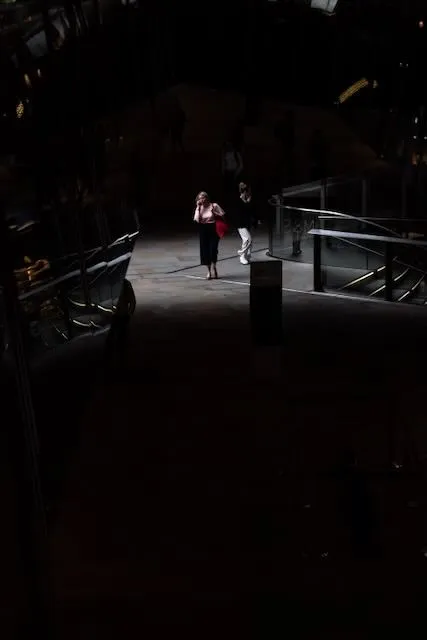 A woman on the phone in bright pink against an almost completely emnpty grey background