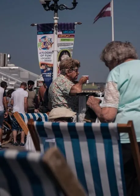 An older woman enjoys a cup of tea by the sea
