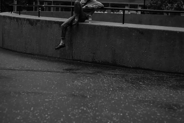 the lower half of a person lounges on a concrete wall