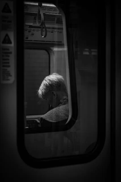 A person seen through two train windows