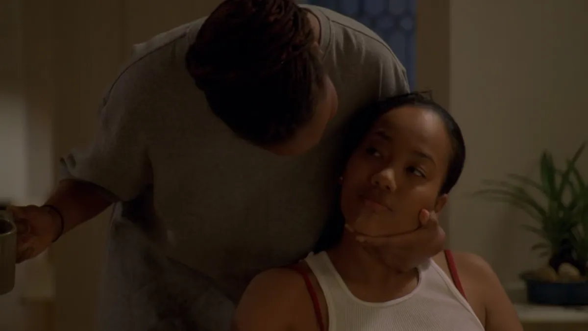 Kima Greggs about to be kissed by her partner.