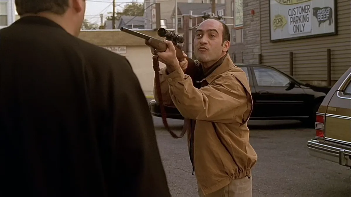 Artie sticking his scoped rifle directly in Tony's face.