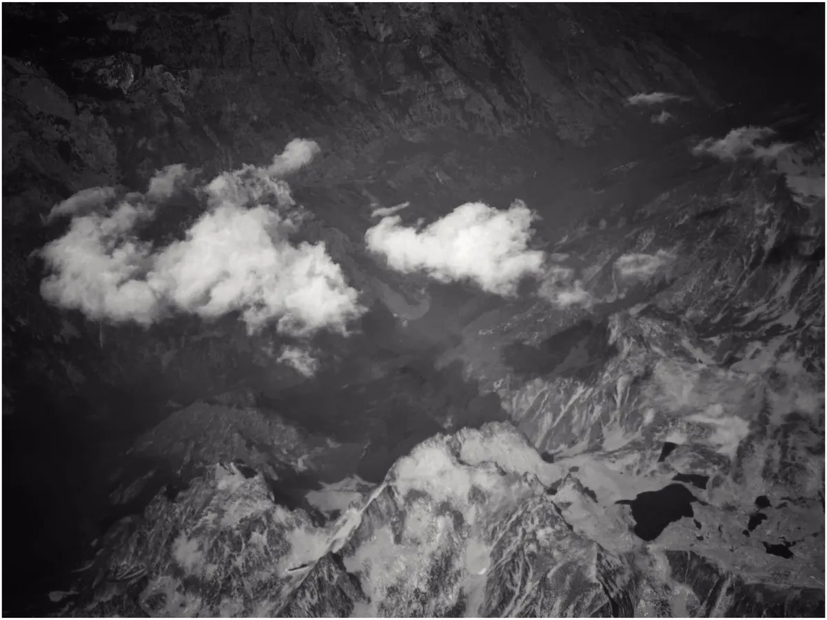 Puffy clouds floating past a mountain vista