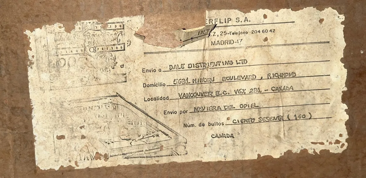 A worn shipping label in Spanish, tracking 160 units of Dragon sent from Madrid to Vancouver.