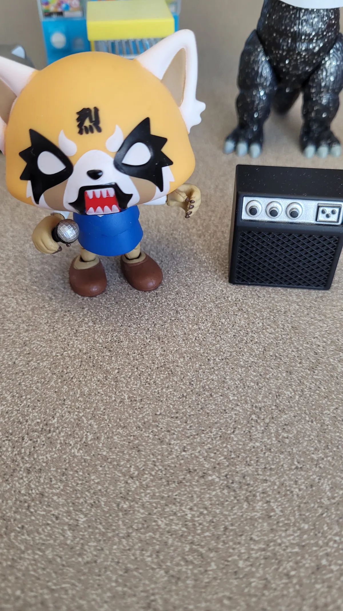 Aggrestuko in metal karaoke mode with a mic and guitar amp