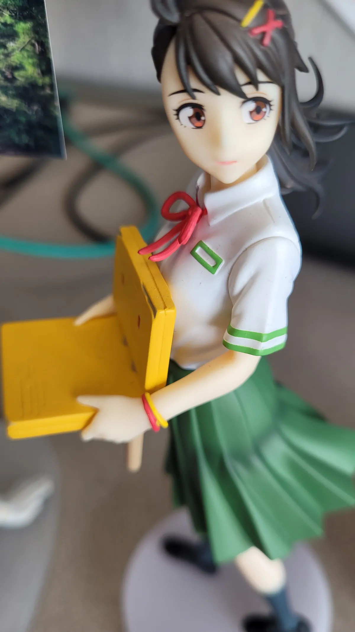 Suzume figure holding a three-legged chair