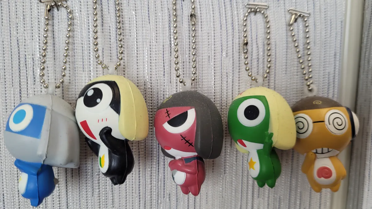 Anime keychains hanging on a cubicle wall