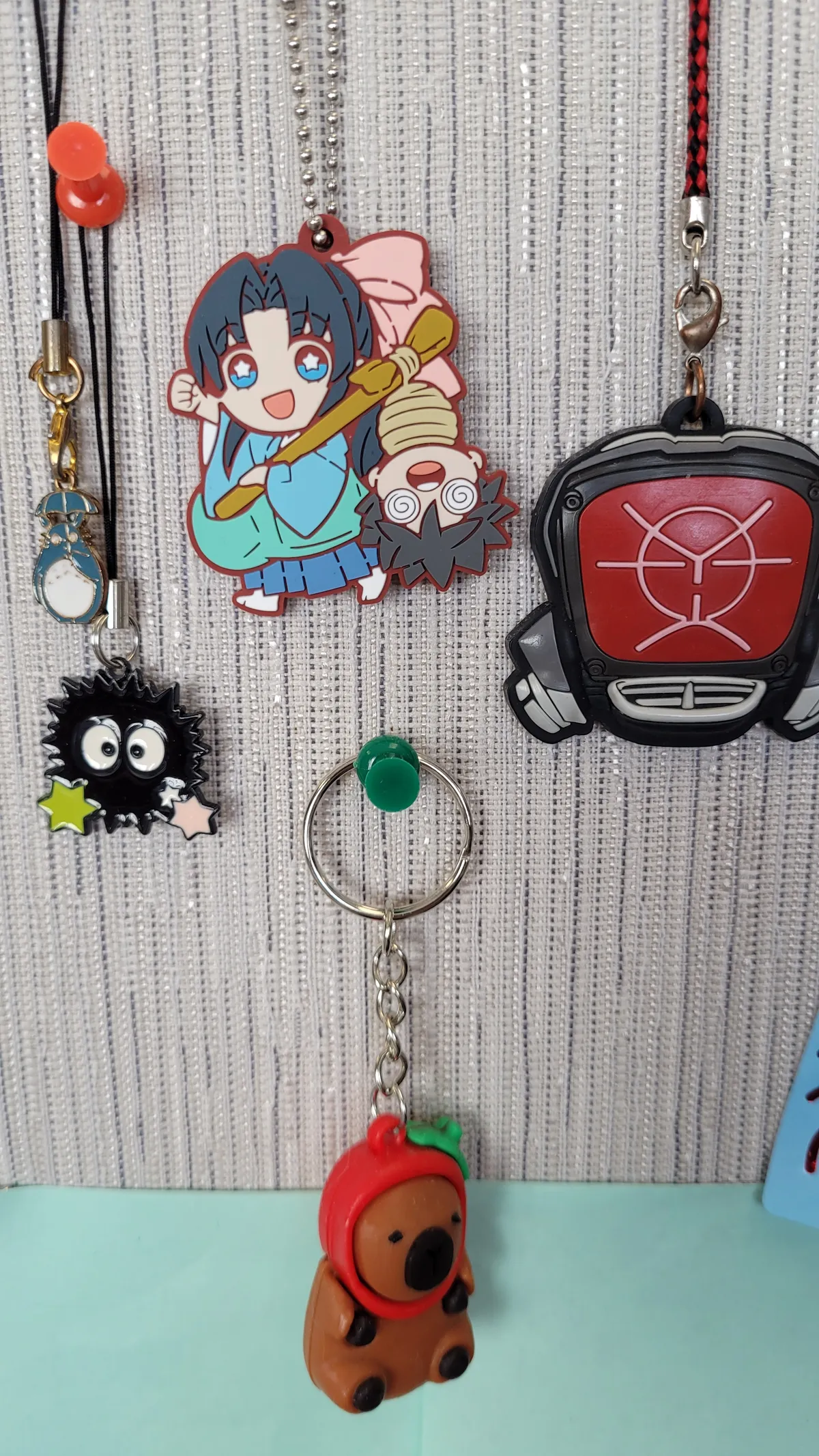 Anime keychains hanging on a cubicle wall
