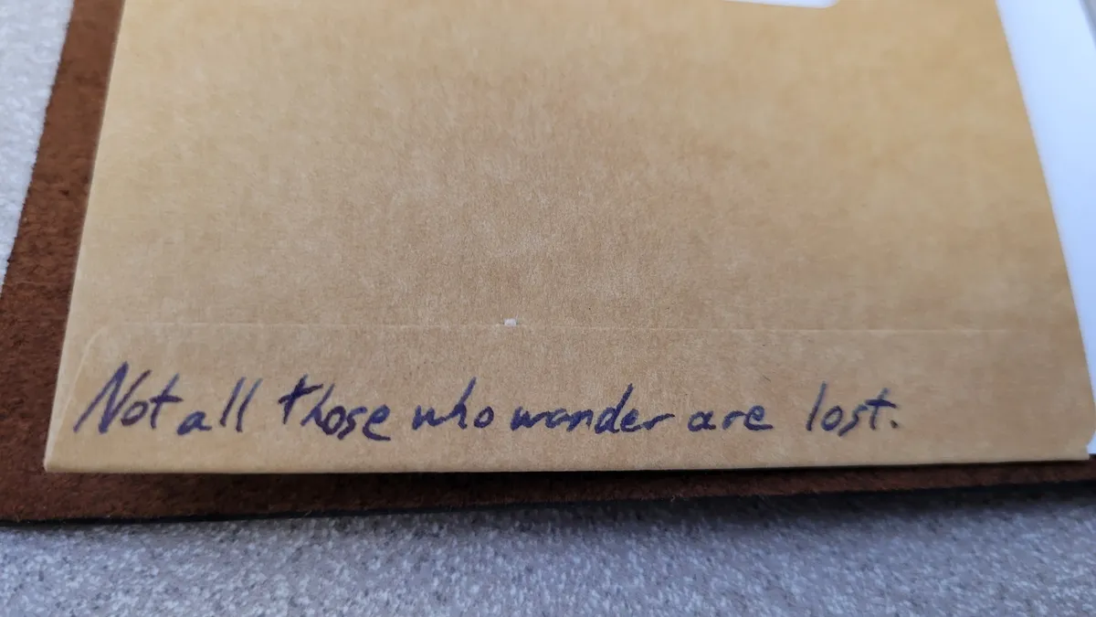 Close-up of a page in a Traveler's Notebook. On it is written- Not all those who wander are lost.