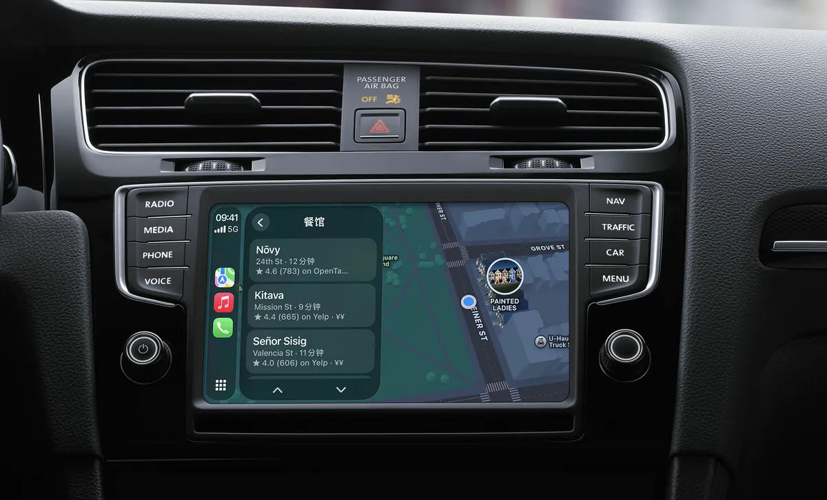 汽车中控台嵌入式触控屏显示Apple CarPlay导航界面，左侧分栏展示「餐馆」搜索结果列表，包含Nōvy、Kitava、Señor Sisig三家餐厅的地址、评分与预计到达时间；右侧地图视图标注当前位置与Painted Ladies地标。屏幕两侧保留RADIO、MEDIA、PHONE、VOICE及NAV、TRAFFIC、CAR、MENU实体按键，上方可见空调出风口与乘客安全气囊关闭警示灯。