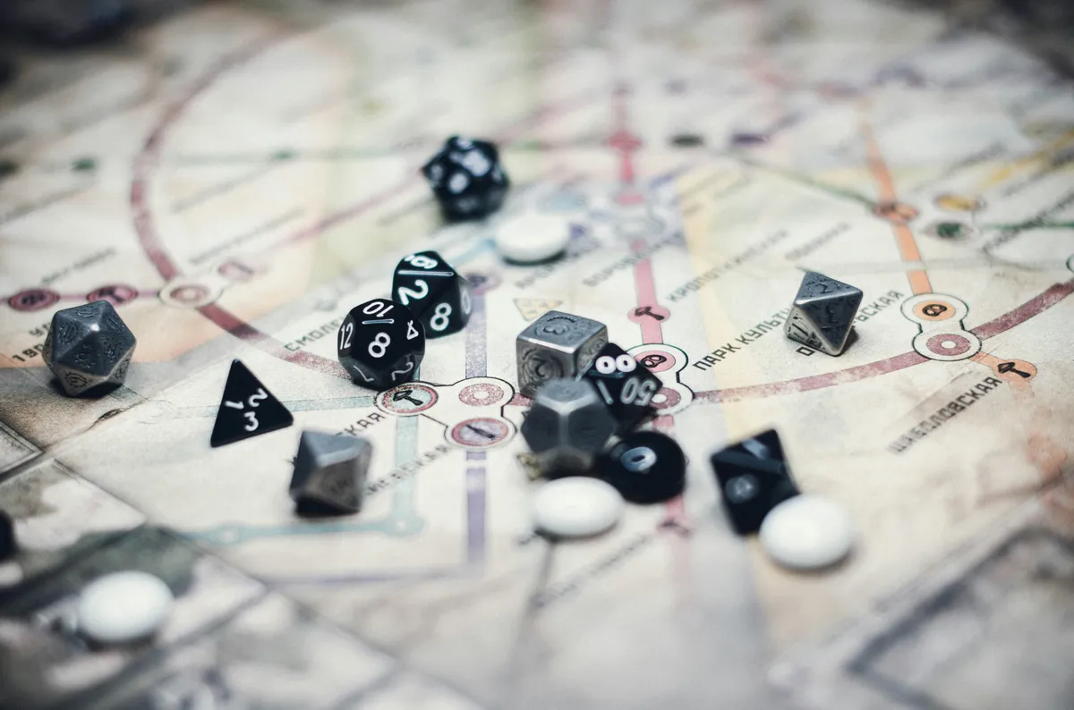 An assortment of black, white, and metal dice strewn across a map