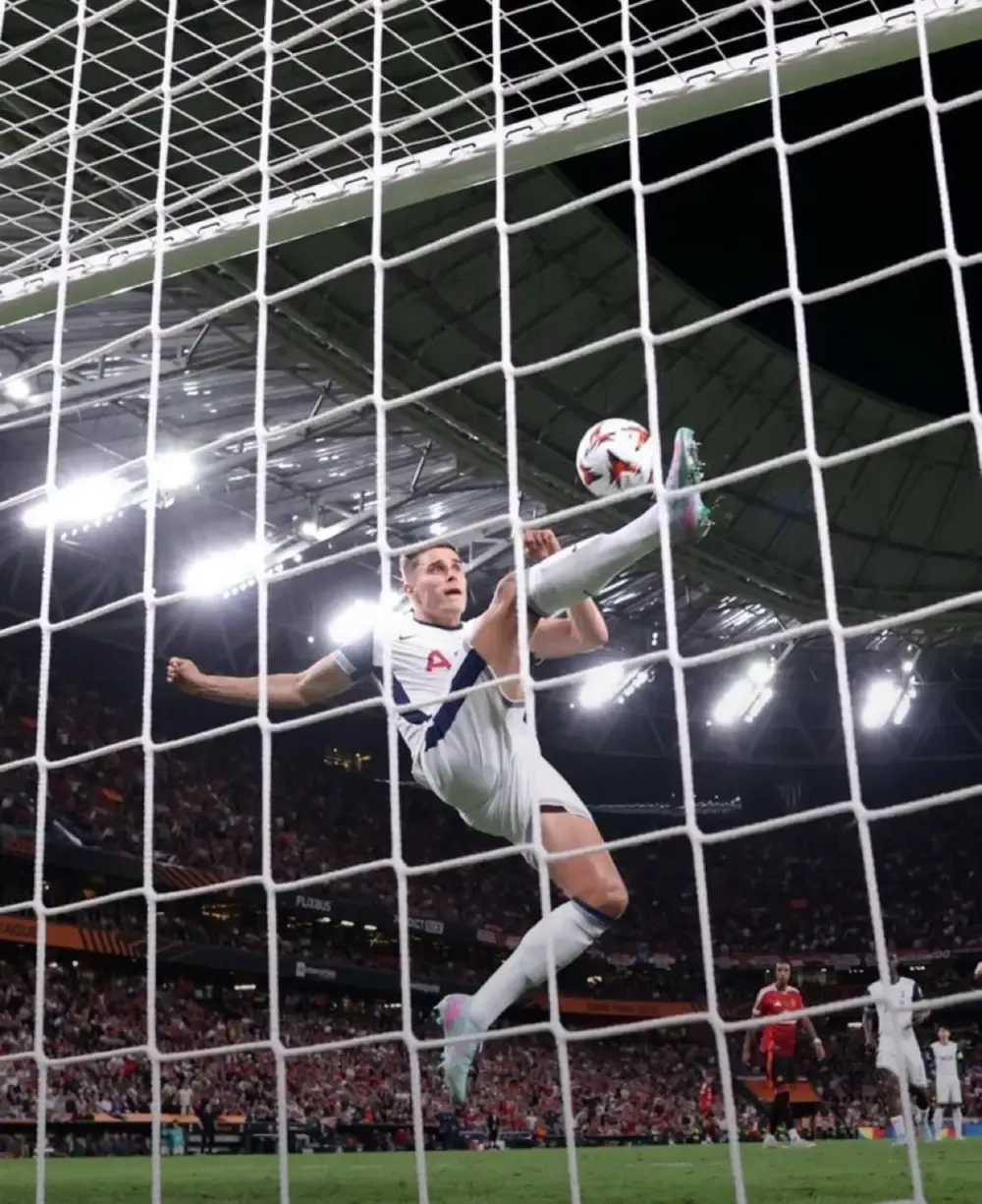 Micky Van De Ven soars to clear the ball and preserve Tottenham's 1 - 0 lead over Manchester United.