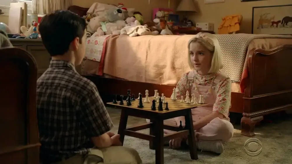 Sheldon and Paige converse over a game of chess.