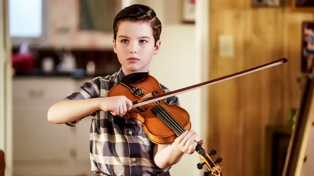 Sheldon holds a violin.