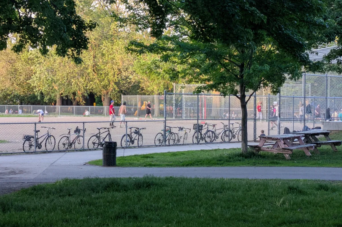 bikes parked at baseball field fence