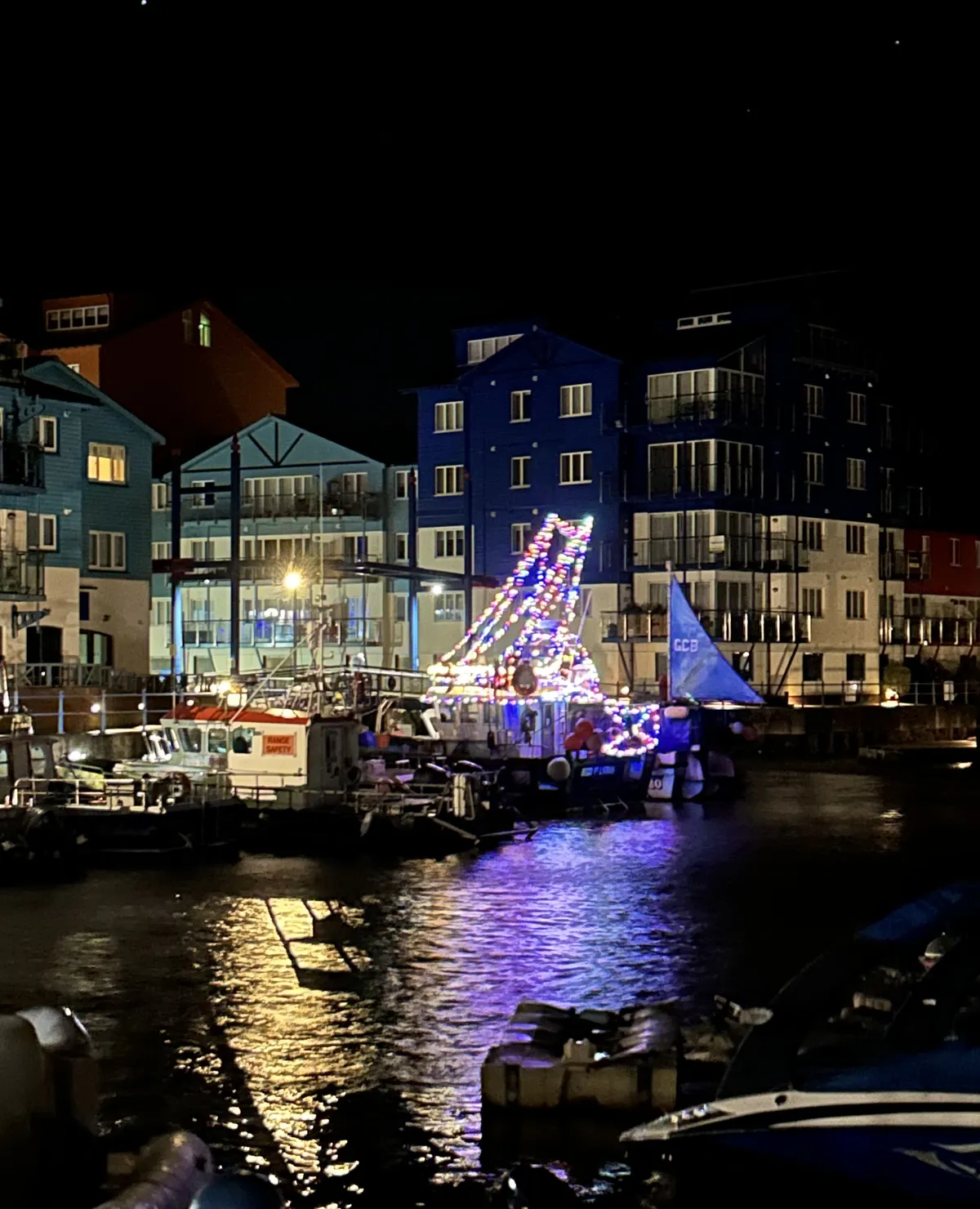 A boat in Exmouth Marina lit up with Christmas lights