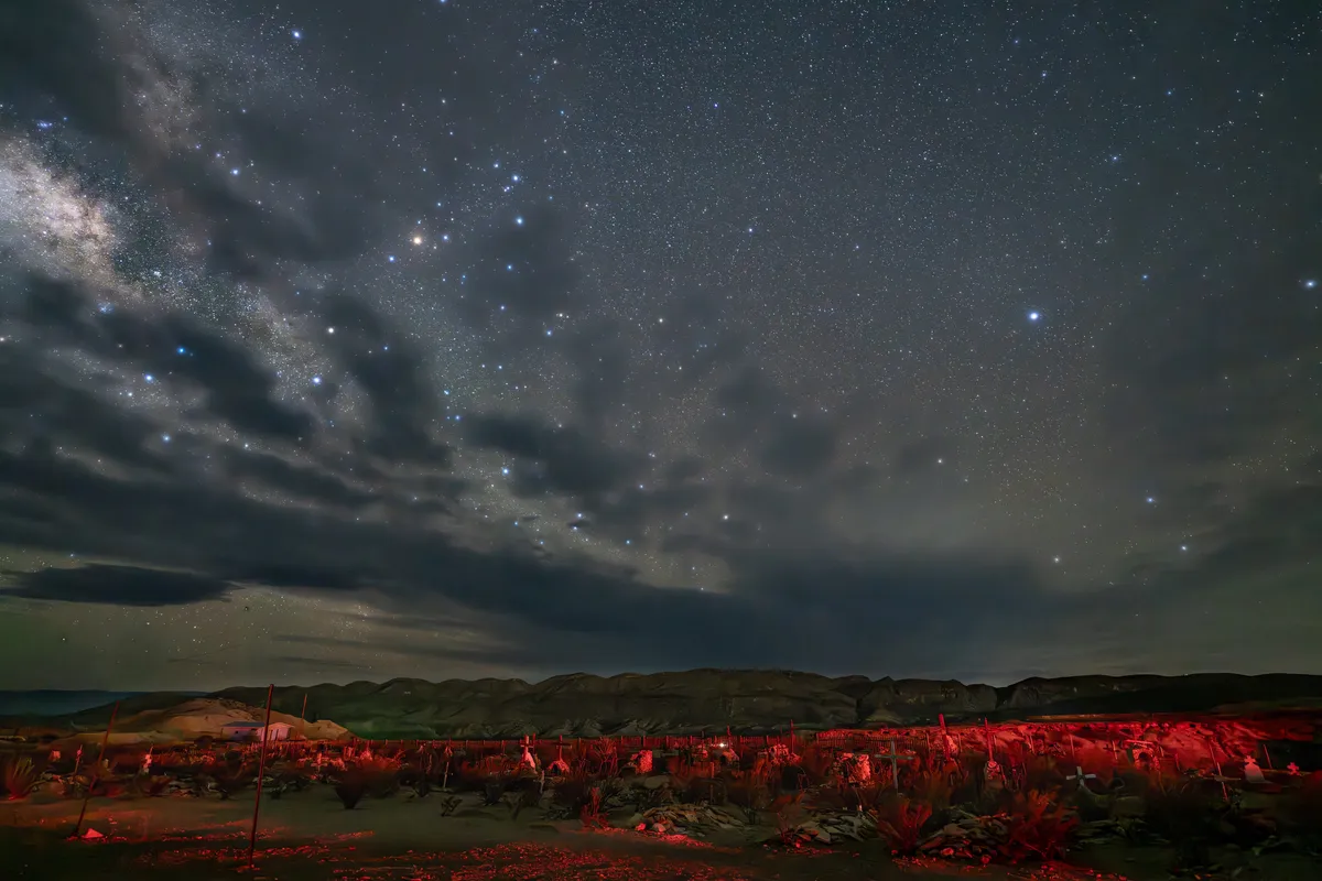 A solitary road cutting through the vast plains of Marfa, Texas, under an expansive sky.