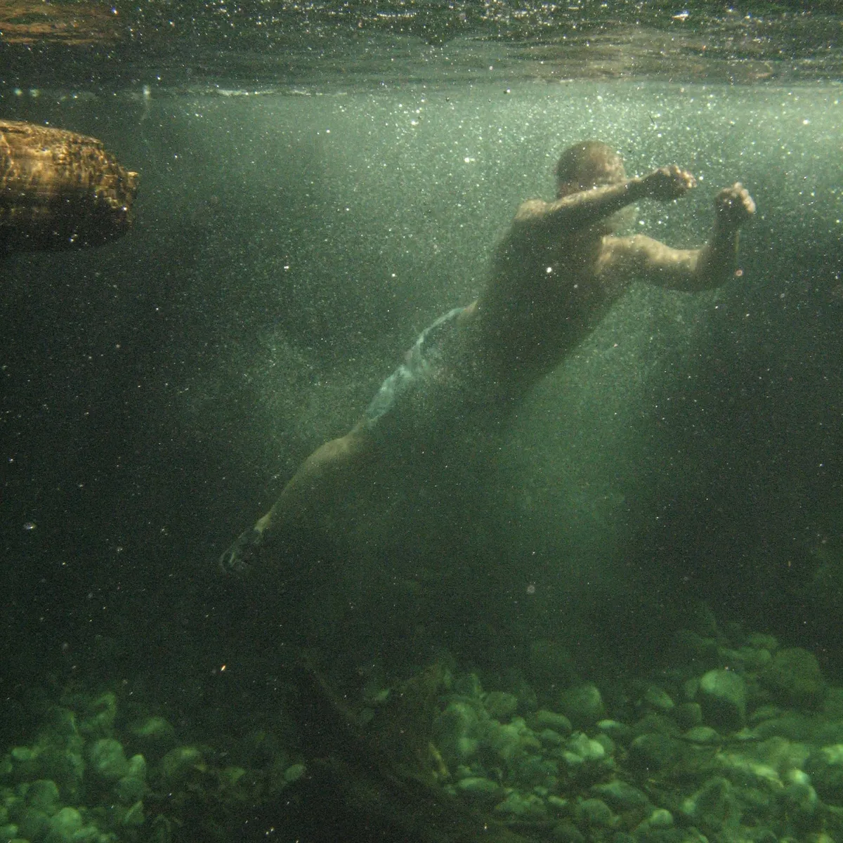 A man obscured in sickly green water.