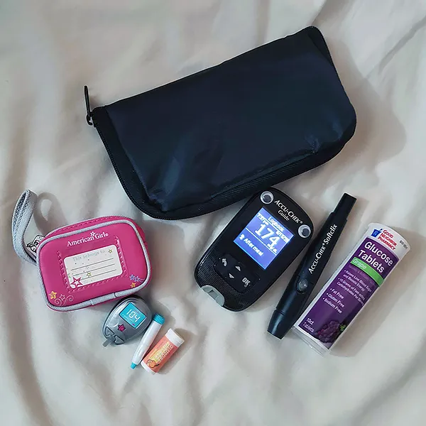 a real diabetes care kit (bag, glucose meter, finger lancet, glucose tablets) laid out on a white background, with the same items in doll form laid out below them