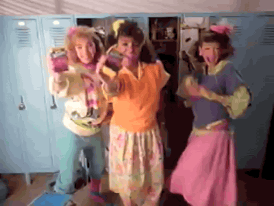 three brightly-clothed 80s girls dancing