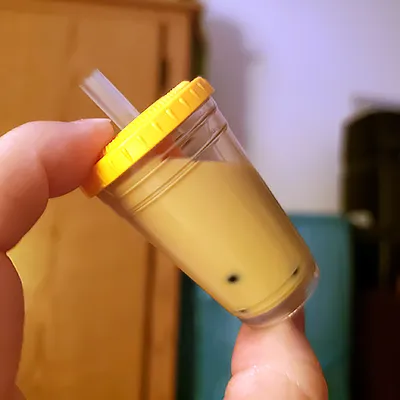 a tiny cup of 'boba milk tea', complete with 'boba' pearls