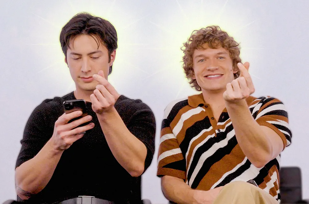 Hudson Williams and Connor Storrie from Heated Rivalry, making hearts with their fingers