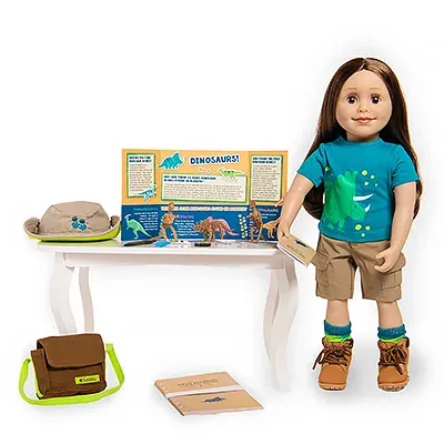 A Maplelea girl doll posing in a dinosaur-themed outfit with 