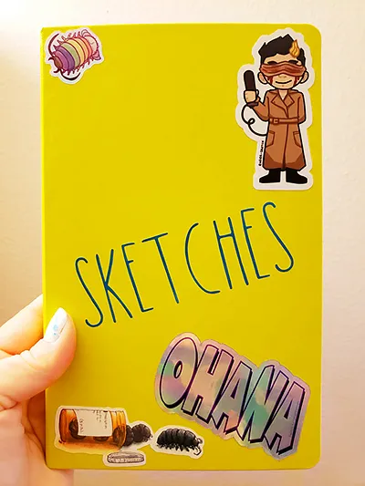 a bright yellow sketchbook deccorated with stickers