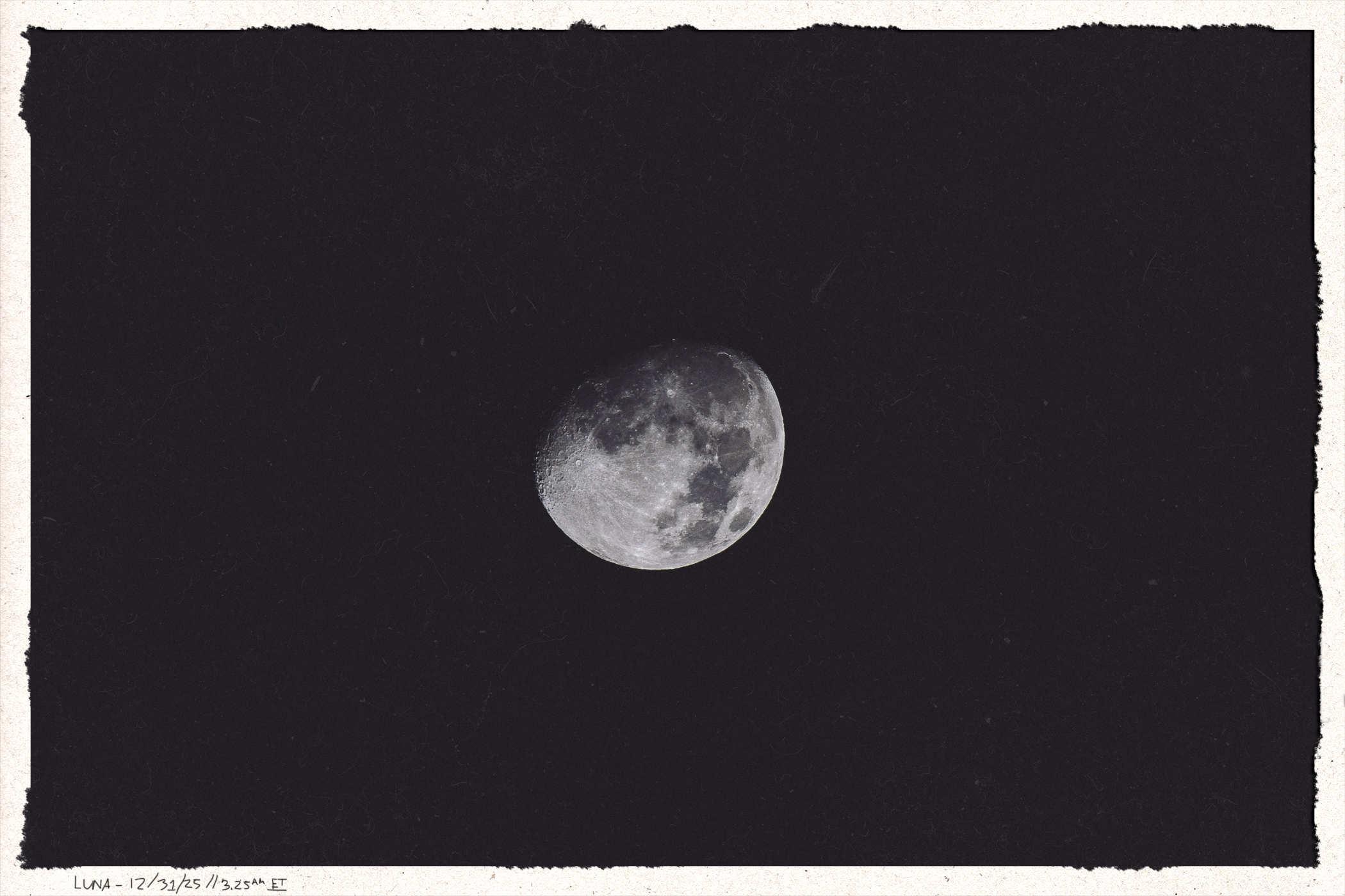 Framed photo of the moon, waxing gibbous, but turned slightly from the previous photo; handwritten in the lower corner is 'Luna 12/31/25 // 3:25AM ET'