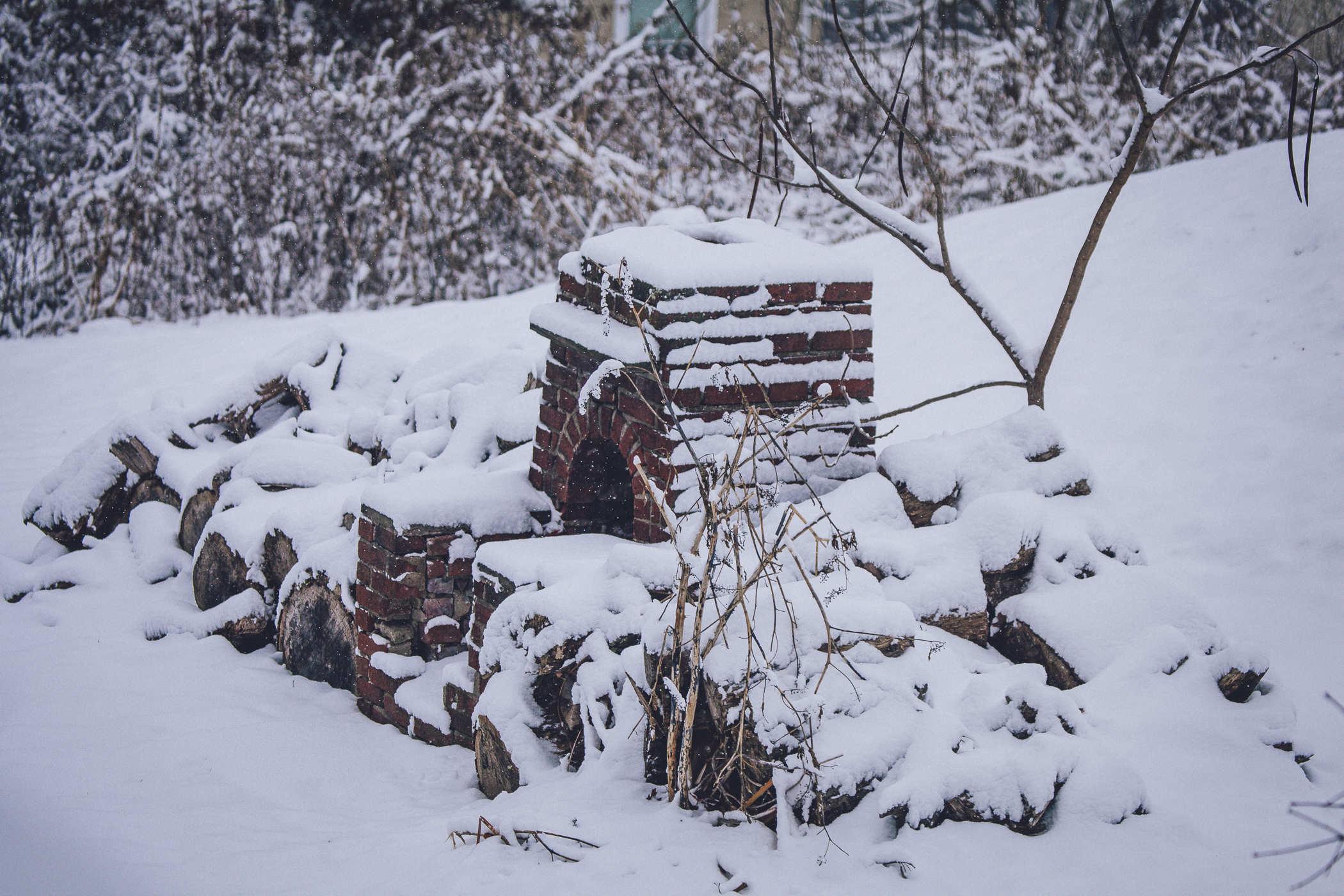 Photo of a brick outdoor oven / fireplace covered in snow