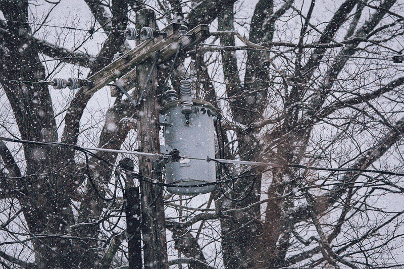 Gif of snow falling on the top of a utility pole's drum