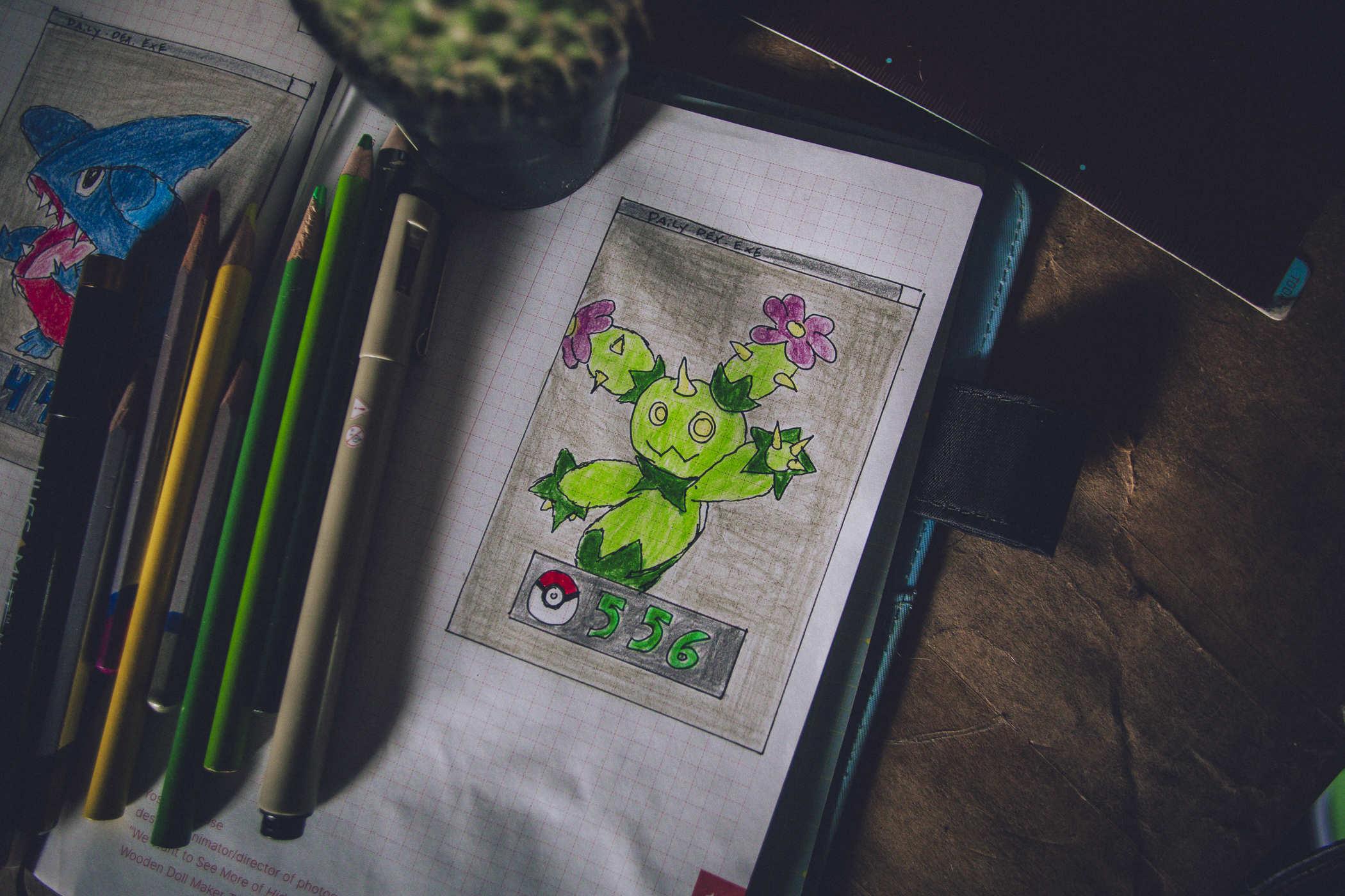 Drawing of pokemon 556; a cactus creature with pink flowered headstalks