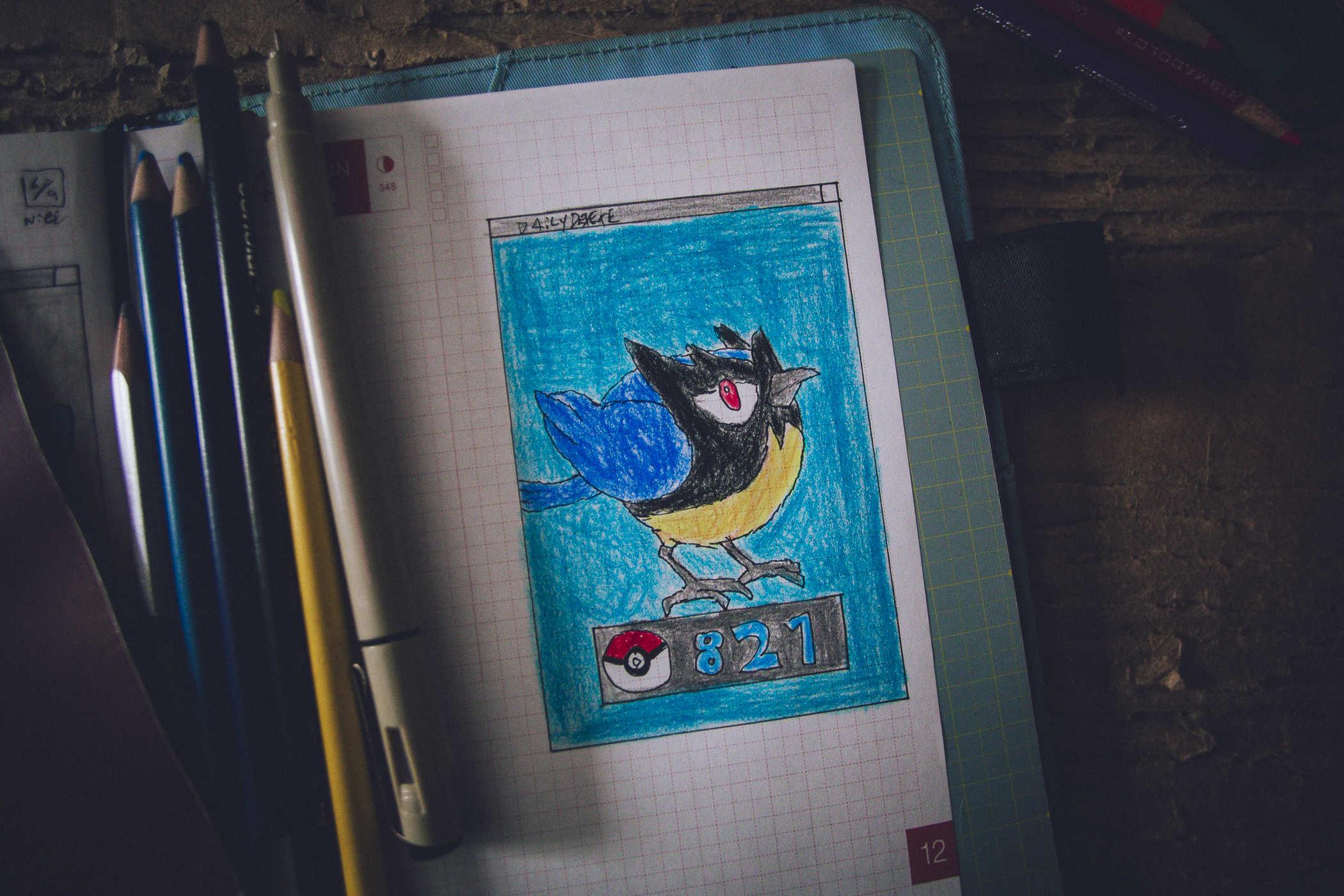 Drawing of pokemon 821; a black and blue and yellow bird