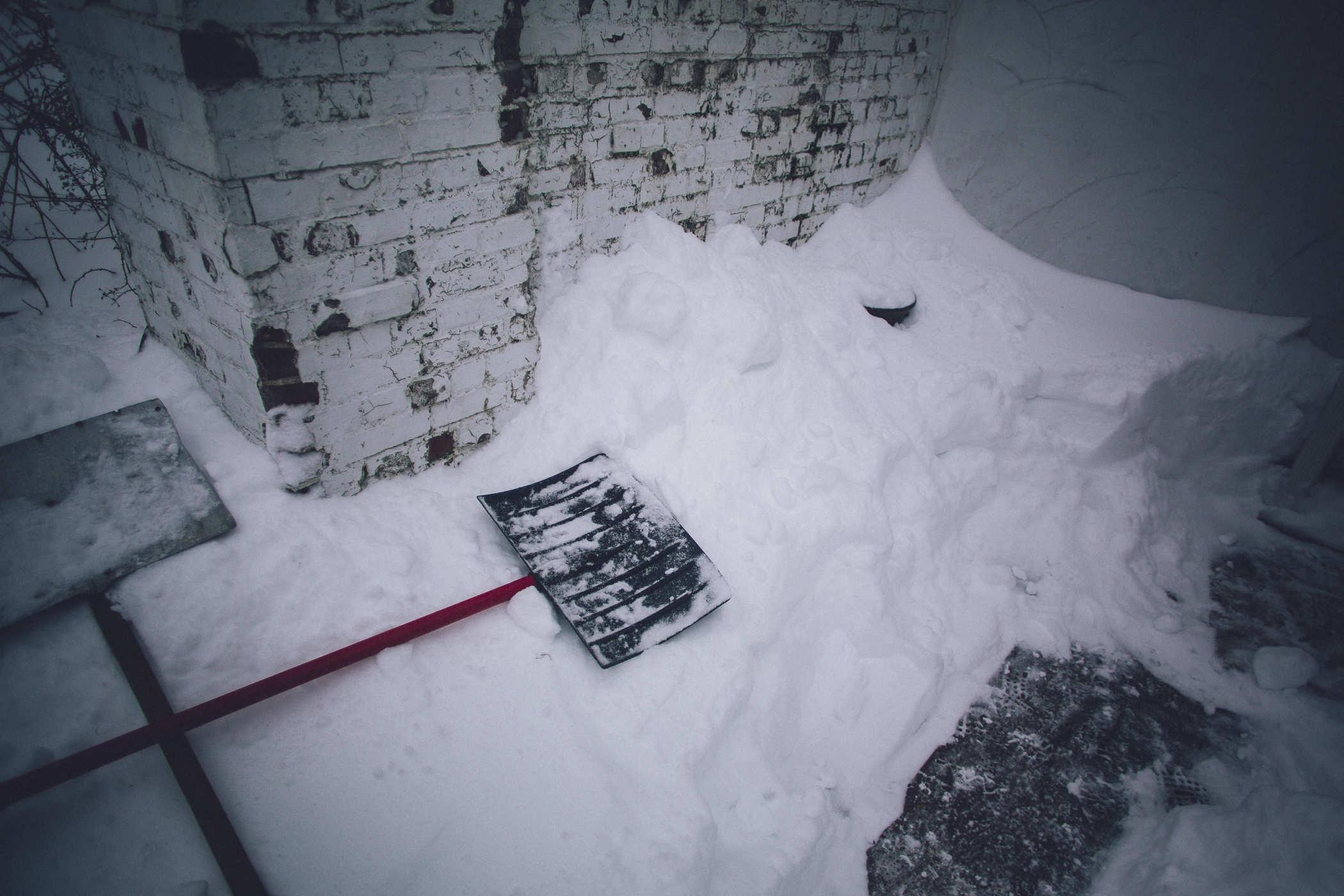 photo of two snow shovels on top of a large mound of snow