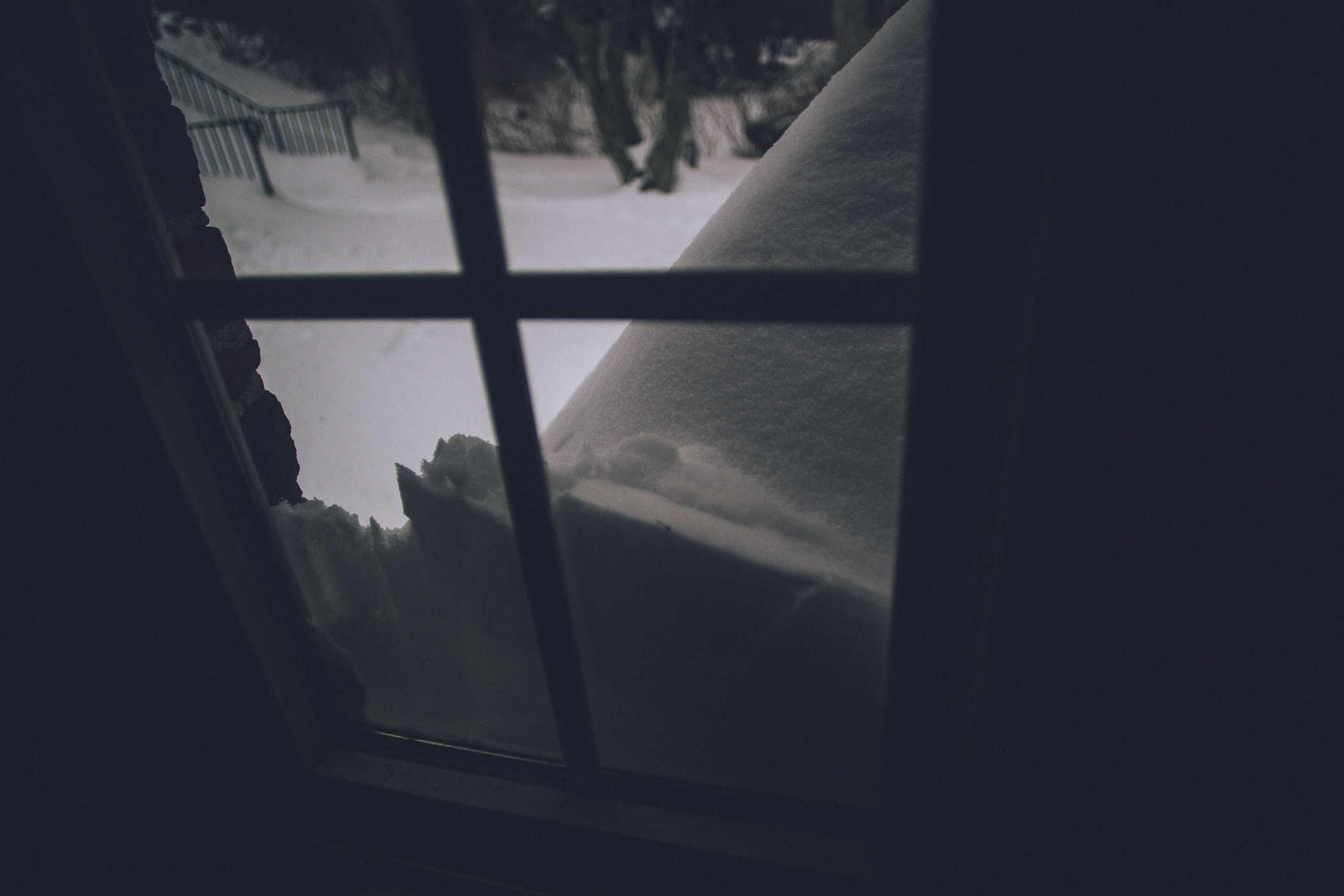 View from inside a window; snow is coming up to cover about half of it