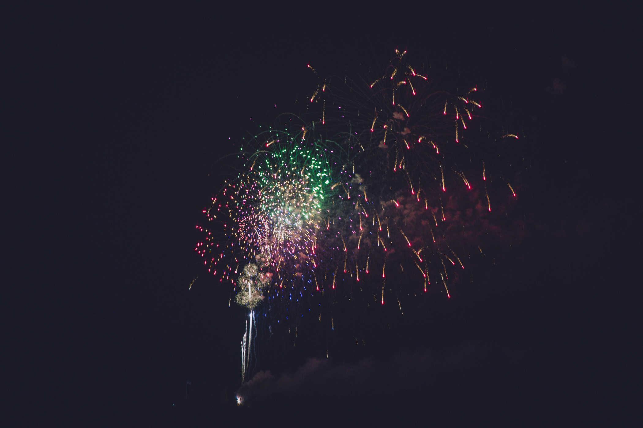 Photos of fireworks both in sky exploding and rockets launching up into the sky