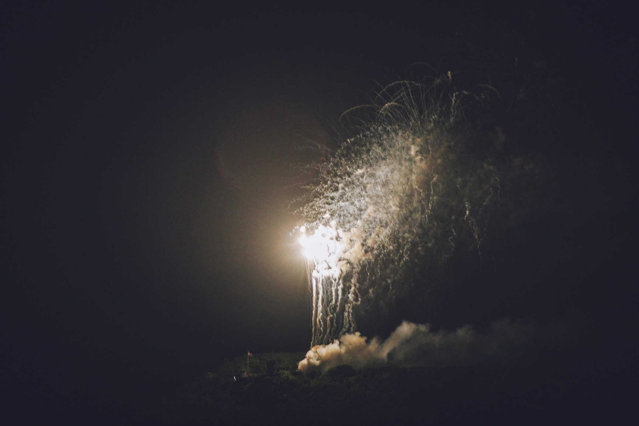 Fireworks being shot up and illuminating the background